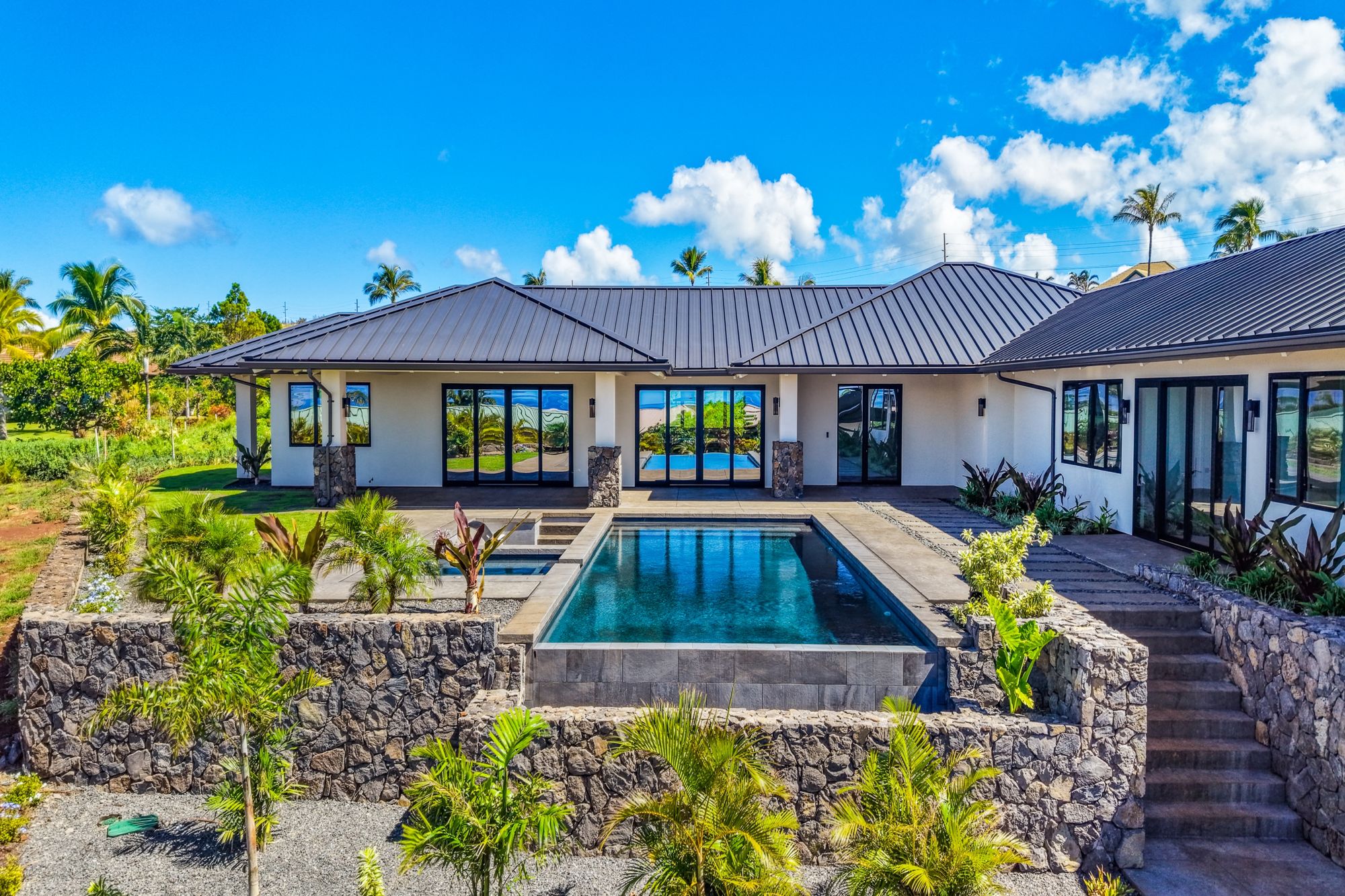 The residence and infinity pool above lava rock terraces